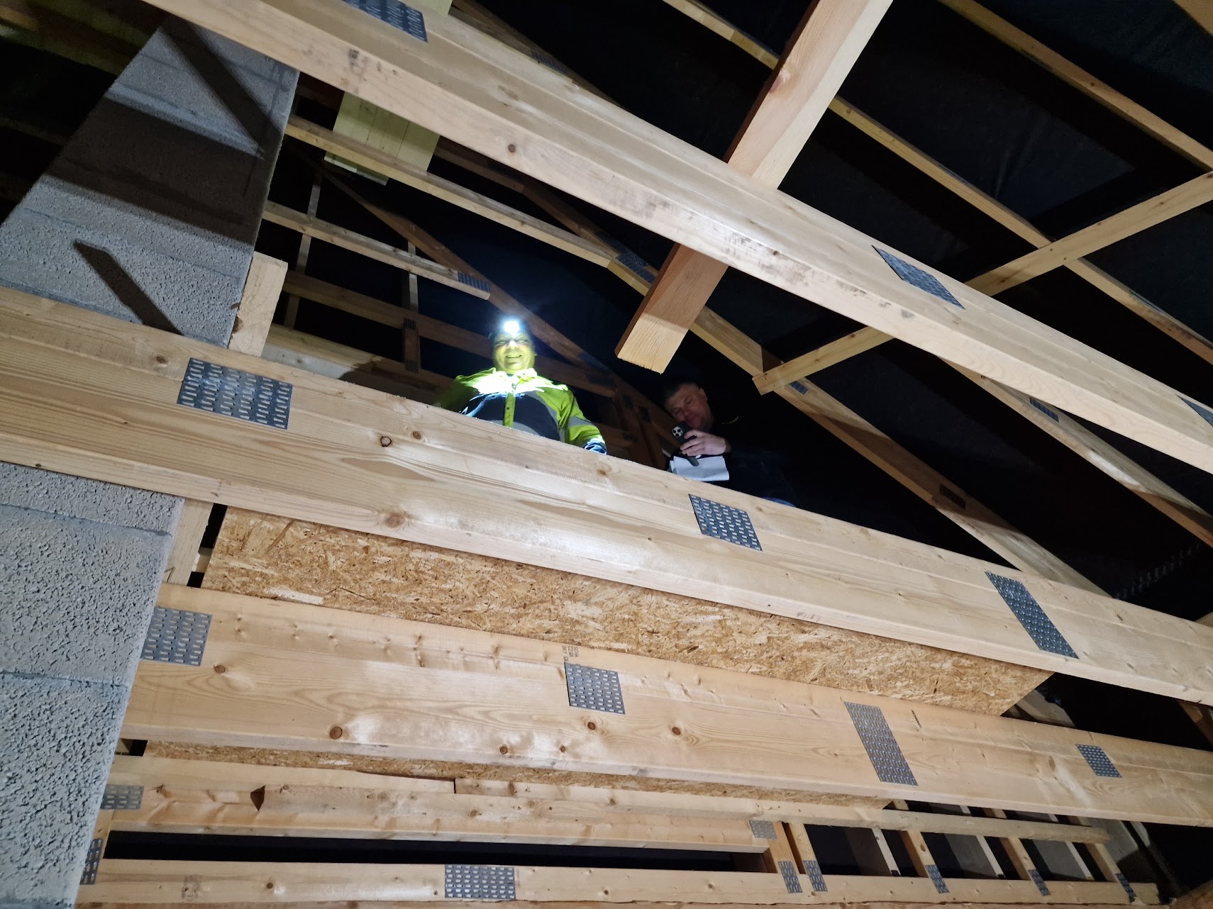 Kaksi miestä keskeneräisen rakennuksen yläkerrassa