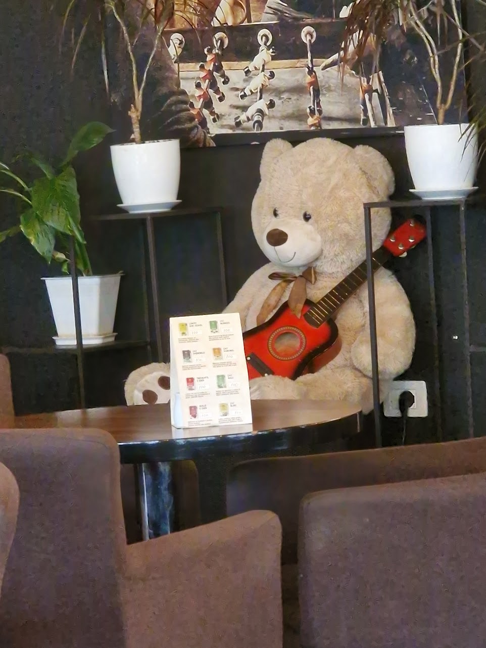 Iso nalle istuu sohvalla ja pitää sylissään kitaraa