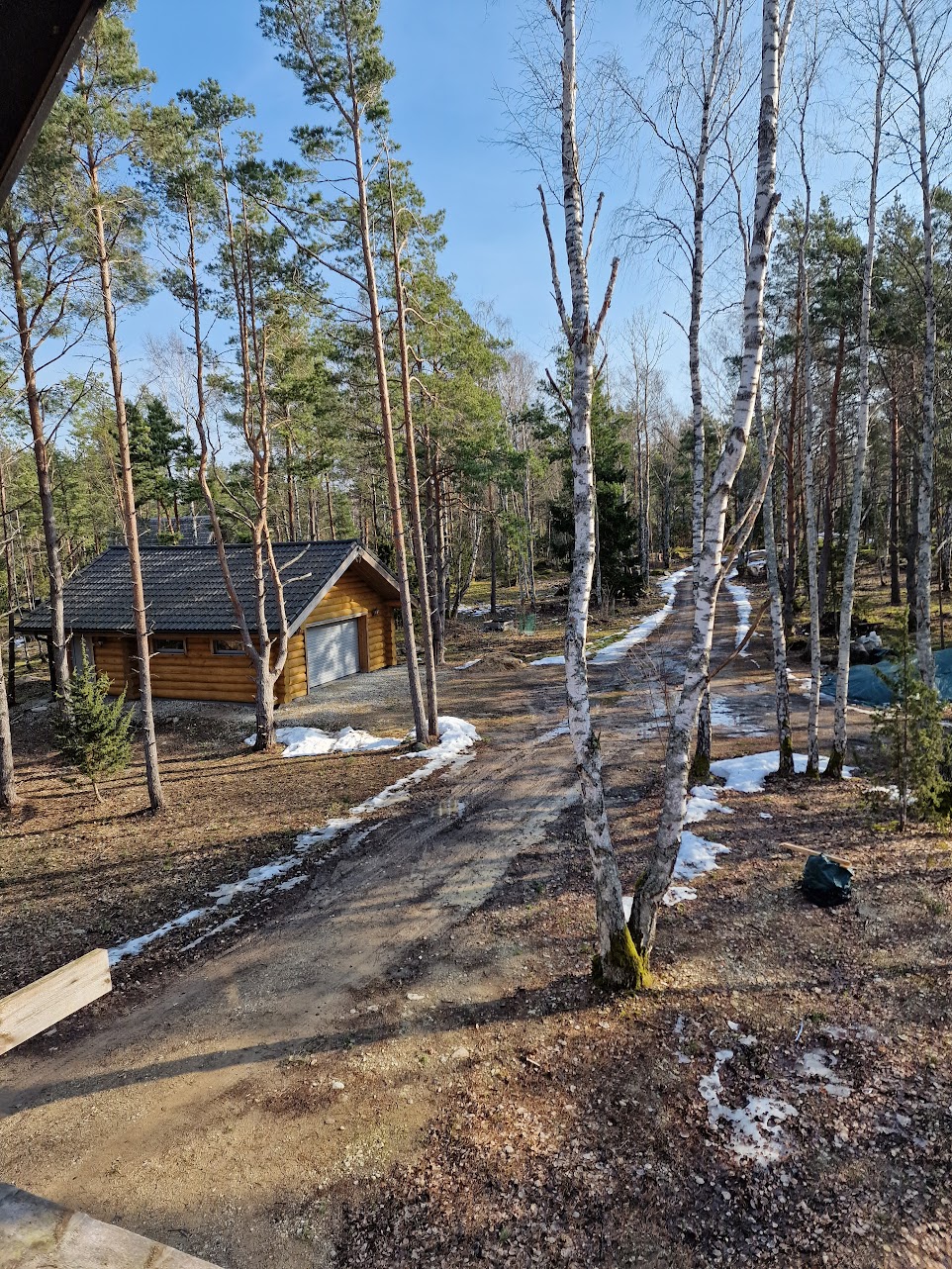 Hirrestä rakennettu autotalli ja pihatie yläkerran ikkunasta nähtynä